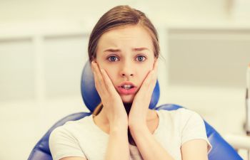 Scared teenage girl in a dental chair.